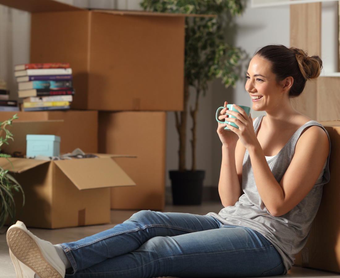 Woman with coffee cup in front of boxes
